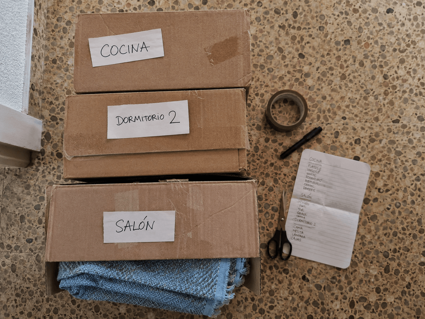 CAJAS DE MUDANZA ETIQUETADAS POR HABITACIÓN (COCINA, DORMITORIO, SALÓN) PREPARADAS PARA UNA MUDANZA RESIDENCIAL