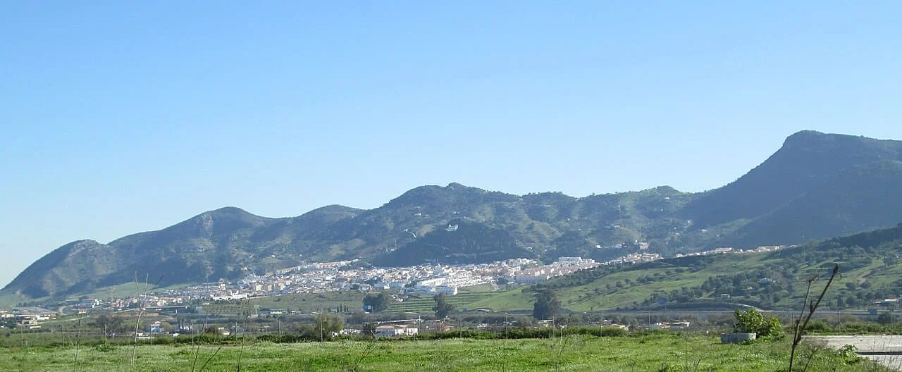OPERARIOS DE MUDANZAS LA SEDA EN CÁRTAMA, CON EL CASTILLO DEL PUEBLO SOBRE LA SIERRA Y LA VEGA DEL GUADALHORCE